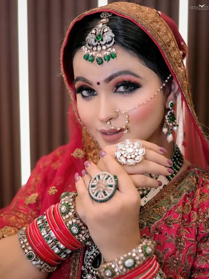 A portrait highlighting the bride's jewelry, with her hands framing her face.