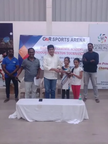 A prize distribution ceremony at the GMR Sports Arena Indoor Badminton Tournament. We collaborate with local sports arenas to promote badminton in different regions.