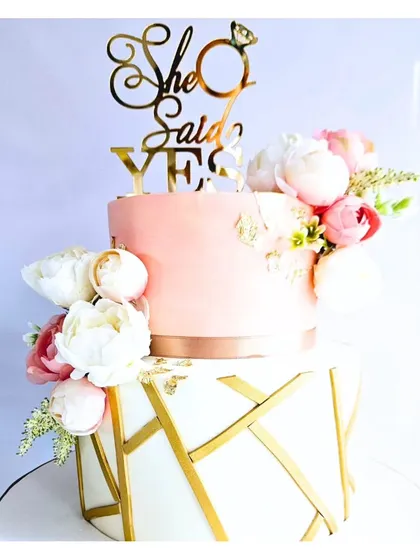 An engagement is a beautiful milestone, and this two-tier cake was designed to celebrate just that. The elegant pink and white design with a geometric gold pattern is adorned with fresh peonies, creating a modern and romantic look.