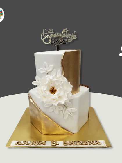 This modern, geometric wedding cake makes a bold statement. The two square tiers are accented with a striking gold leaf design and a large, handcrafted white sugar flower.