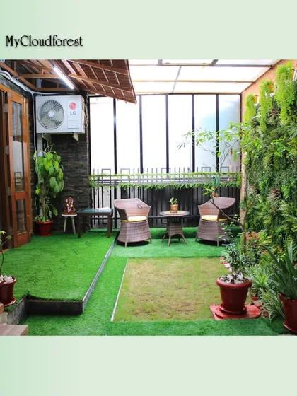 This is a complete patio transformation, showcasing how I integrate different elements. The space features a full artificial vertical garden wall for privacy and beauty, soft artificial grass underfoot, and a comfortable wicker seating area, creating a self-contained outdoor room.