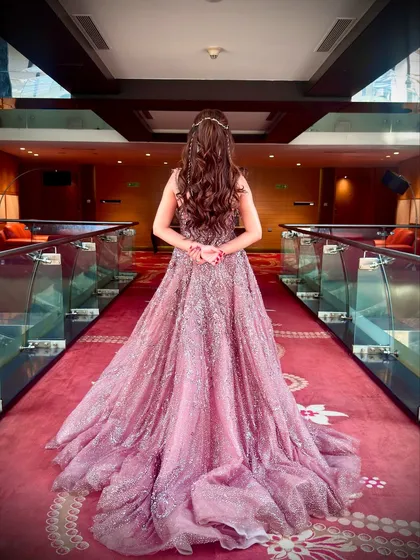 A view from the back, showcasing the stunning mauve gown and the intricate, whimsical hairstyle. The entire look, from the makeup to the hair, was designed to feel like a modern fairytale.