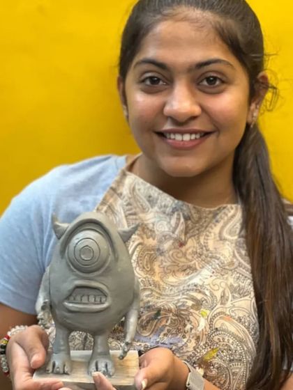 Student Hena with her fantastic sculpture of Mike Wazowski from the movie Monsters, Inc. This project helped her develop skills in creating animated forms, expressions, and textures in clay.