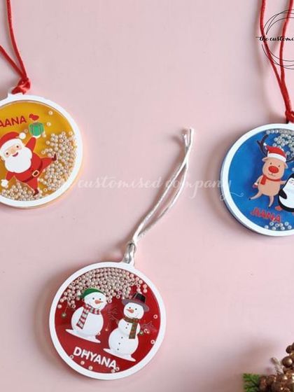 These custom Christmas baubles are filled with faux snow and beads, featuring festive characters and a personalized name for a magical touch on your tree.