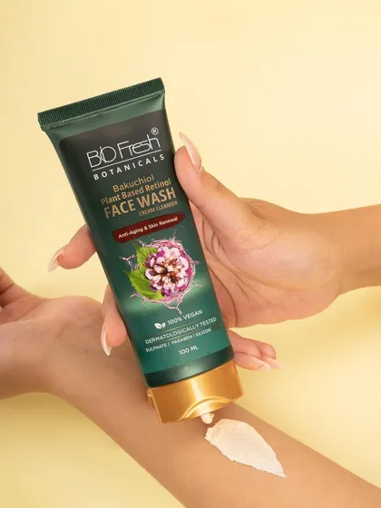 A texture and application shot for Biofresh Botanicals' face wash. This image demonstrates the product's creamy consistency and is styled to convey a sense of clean, gentle skincare, perfect for beauty brand websites and social content.