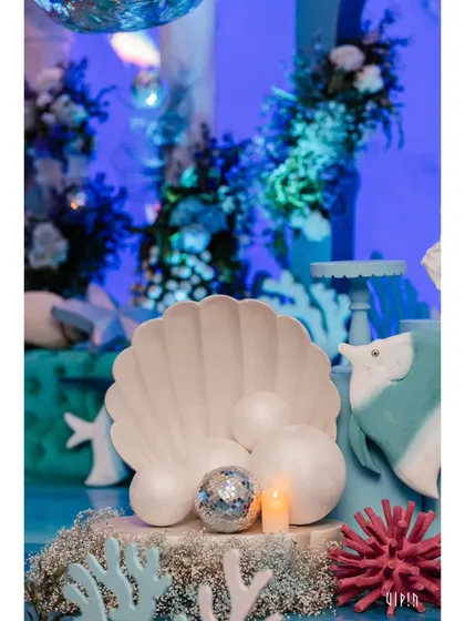 A close-up of the ocean-themed decor, featuring a large seashell, pearls, and a sparkling disco ball. I use a mix of textures and materials to create visually interesting tablescapes.