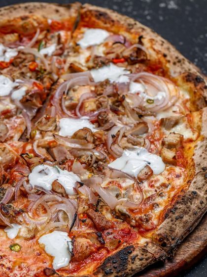 Introducing the Bird in Hand pizza. This pie balances the heat of bird's eye chili with roasted chicken and creamy blue cheese on our signature sourdough base.