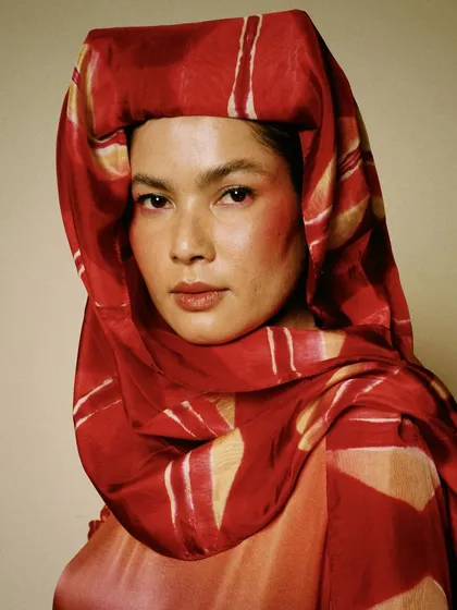 A vibrant studio portrait from a collaboration with House of Wandering Silk. The rich colors and textures of the fabric, combined with the model's direct gaze, create a powerful and artistic statement.