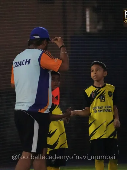 A coach offers encouragement and a high-five, building a positive and motivational relationship with the players.