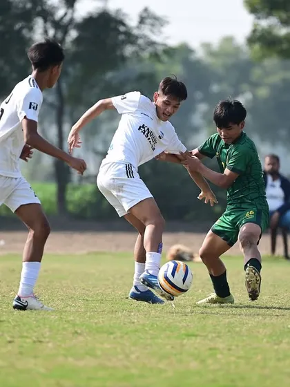 Two of our players battling for possession in the midfield during the Dream Sports Championship. We train our players to be relentless and competitive.