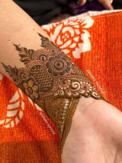 A close-up of a semi-bridal armband, featuring delicate floral and net patterns.