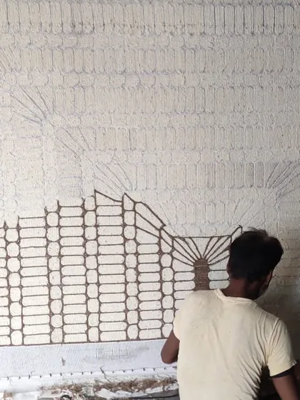 A craftsman working on the intricate pattern of a custom rug. We collaborate with talented artisans to bring our unique designs to life.