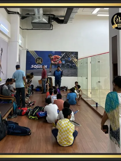 A group of young players receives instruction from a coach beside our squash courts. We are committed to nurturing the next generation of athletes in a supportive environment.