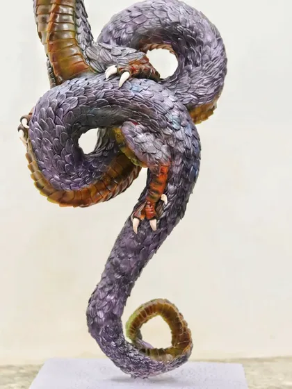 A view of the intertwined body of the Ouroboros dragon cake, showing the detailed, hand-painted scales and dynamic pose.