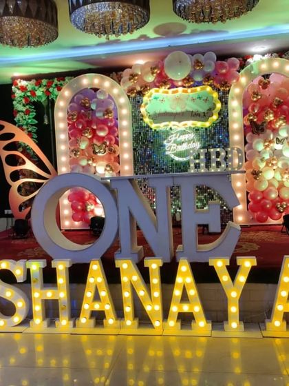 A stunning Butterfly theme stage for 'SHANAYA', with large marquee letters, butterfly wing props, and a sequin backdrop.