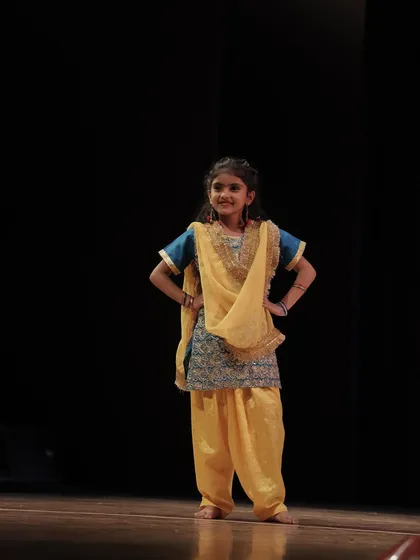 A full-length shot of a young performer, poised and ready. We ensure our students are well prepared and confident before they step on stage.