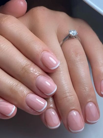 This classic French manicure on short, rounded nails is perfect for everyday elegance. The glossy finish makes the nails look healthy and polished.