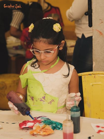 Focused and creative, this child is in the zone, adding colorful dyes to her project. I love seeing kids so absorbed in the artistic process.