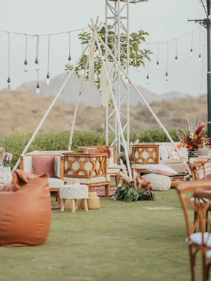 A bohemian-inspired lounge area with low seating, bean bags, and a teepee-like structure under string lights, creating a relaxed and free-spirited atmosphere for the Mehendi.