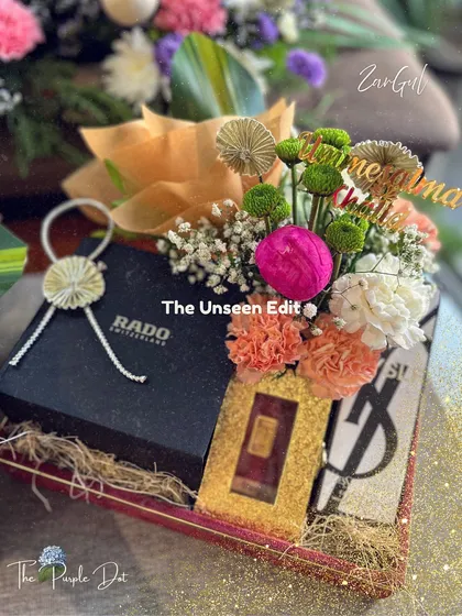 I take great pride in creating gifts for the groom that are both sophisticated and personal. Here, I have styled high-end gifts like a Rado watch and YSL fragrance with fresh, vibrant florals and a custom name tag, ensuring the presentation is as memorable as the gift itself.