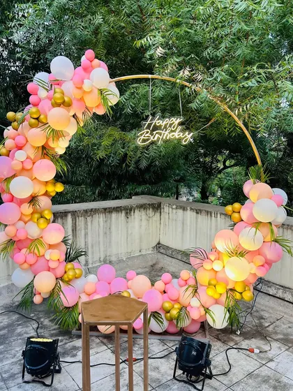 This angle shows how uplighting can enhance an outdoor balloon decoration at dusk. The lights make the colors of the balloons on the ring arch appear even more vibrant.