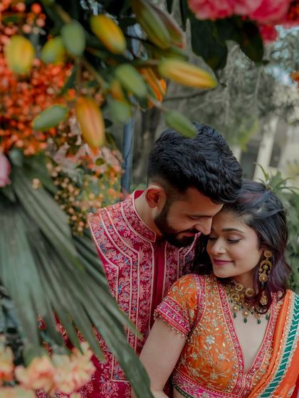 An intimate portrait of the couple nestled within a lush floral arrangement.