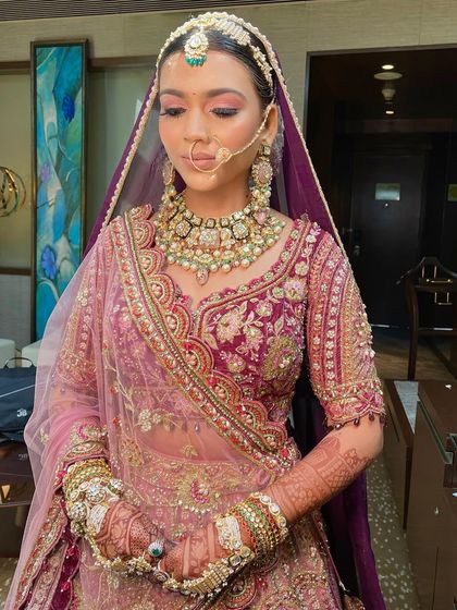 A close-up of the bride's serene expression, her hair perfectly styled for her wedding day.