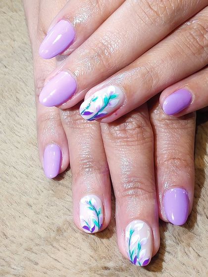 A lovely lavender set with a touch of artistry. Two accent nails feature delicate, hand-painted floral sprigs in shades of teal and purple on a white base.