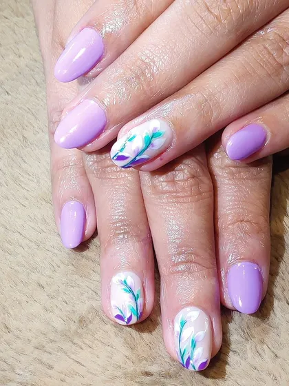 A lovely lavender set with a touch of artistry. Two accent nails feature delicate, hand-painted floral sprigs in shades of teal and purple on a white base.