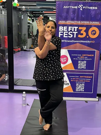 A participant smiles while holding the Eagle Pose, capturing the positive and encouraging vibe of our community events.