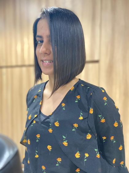 The stunning "after" of a precision bob haircut. The cut is sharp, asymmetrical, and perfectly straight, showcasing a modern and sophisticated style.