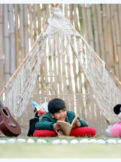 A cozy and imaginative reading moment in our outdoor teepee setup, complete with a guitar and a Mickey Mouse plush toy.