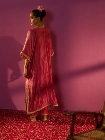 A back view of the Kashidaa silk kurta, highlighting the garment's fluid drape and delicate gold trim. This shot emphasizes the craftsmanship and elegant silhouette of the design.