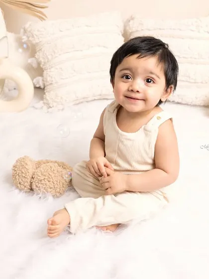 Soft hues, sweet smiles, and pure innocence. This one-year-old's portrait in a neutral, boho-themed setup is simply timeless.