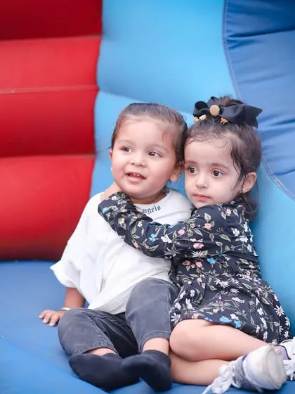 Two little friends sharing a hug in a colorful bounce house. We capture the fun and friendships at birthday parties.