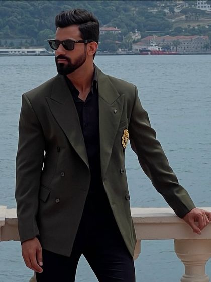 A closer view of the olive green double-breasted blazer, highlighting its sharp tailoring and distinctive details.