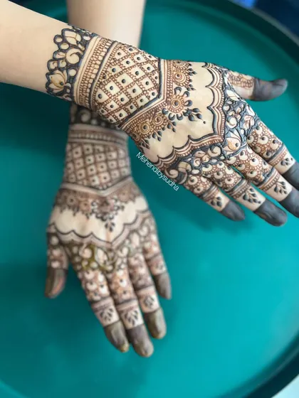A beautiful short-hand mehendi design. The pattern is contained to the hand and wrist, featuring a check pattern and a delicate border.