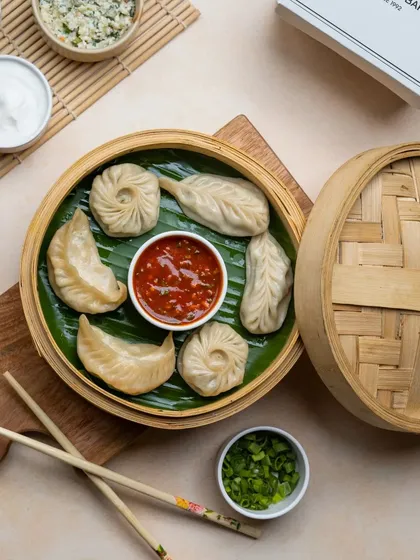 A variety platter of our steamed momos, showing the different shapes and sizes we create. It's perfect for sharing and trying a little bit of everything.