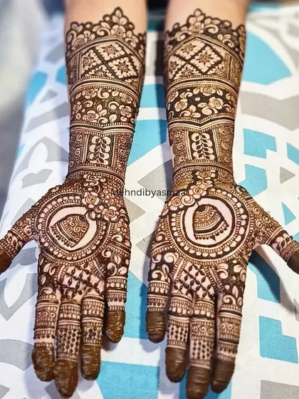 This bridal design features a beautiful heart motif on the palm, surrounded by intricate checks, florals, and bands on the arm.