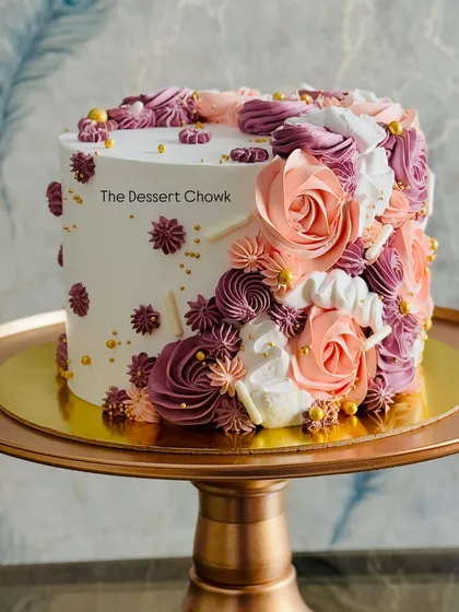 I adore creating elegant floral cakes. This tall chocolate truffle cake features a cascade of hand-piped buttercream flowers in beautiful pastel shades, perfect for birthdays, anniversaries, or any sophisticated event.