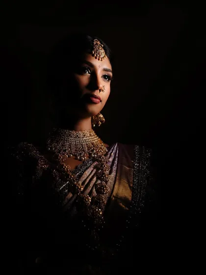 An artistic bridal portrait using dramatic light and shadow. We focus on creating images that are more than just photos; they are timeless portraits that highlight the bride's elegance and strength.