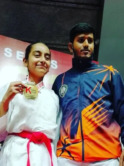 A proud coach with his student after she won her medal at the India Open International.