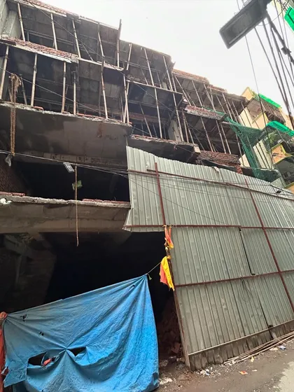 The exterior of the Mehrauli project during the structural phase, showing multiple floors cast and brickwork in progress.