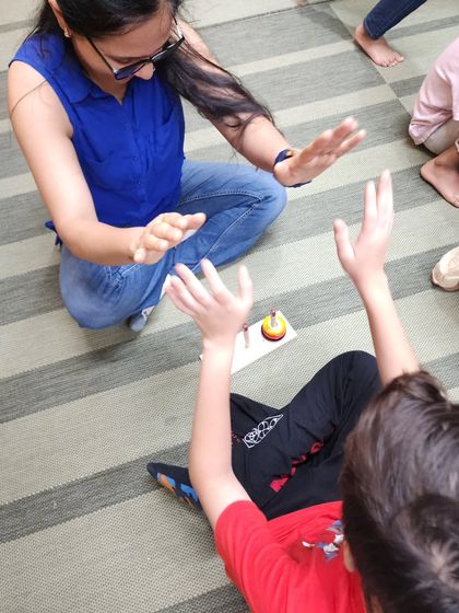A moment of fun and connection as a parent and child play a hand-clapping game. These simple, timeless games are a core part of our workshops, fostering joy and bonding.