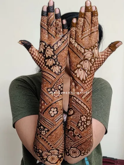 Full coverage bridal henna with beautiful floral and paisley patterns. The design extends from the fingertips to the elbows for a complete look.