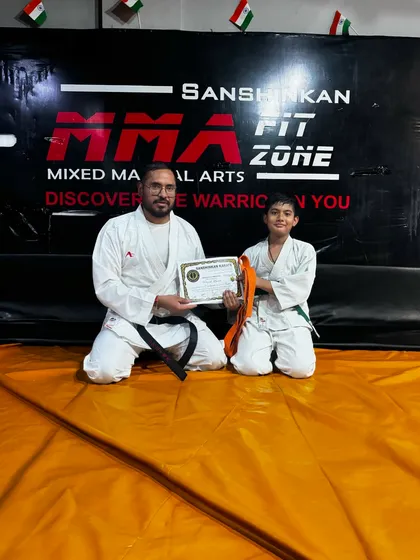This young student has earned his orange belt. Our structured belt system provides clear goals for our students to strive for.