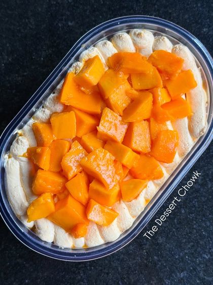 A top view of the Fresh Mango Cake Tub, showcasing the generous amount of fresh, diced mangoes on top.