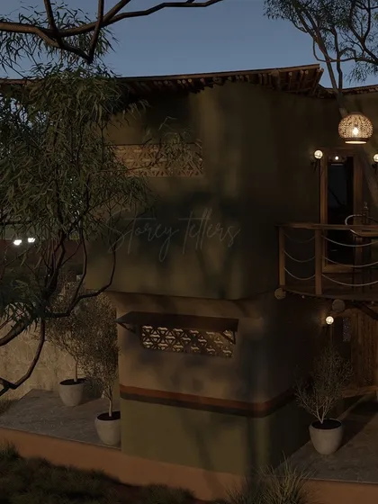 An evening view of the building's exterior, where the warm interior light glows through the windows. The design incorporates small balconies and potted plants to further integrate the structure with its green surroundings.