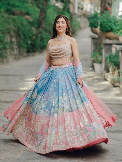 The bride, Shailja, twirls in her stunning pastel blue and pink Mehendi lehenga. This shot captures the beautiful movement and colors of her outfit.