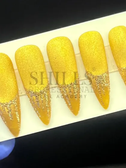 A glamorous set of gold glitter nails, featuring a textured sugar effect and sparkling glitter drips.